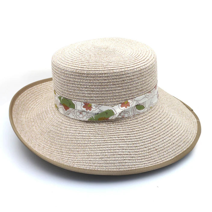 A stylish mix camel Flexibraid® hat featuring a reverse trilby-style brim, flat crown, beige contrasting ribbon edge, and a Liberty floral puggaree band. Offers UPF50+ sun protection and a ComfyFit adjuster for a perfect fit.