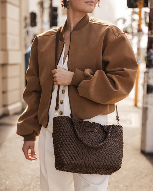 A stylish woven tote bag with top handles and an adjustable crossbody strap, perfect for effortless everyday elegance and versatility.