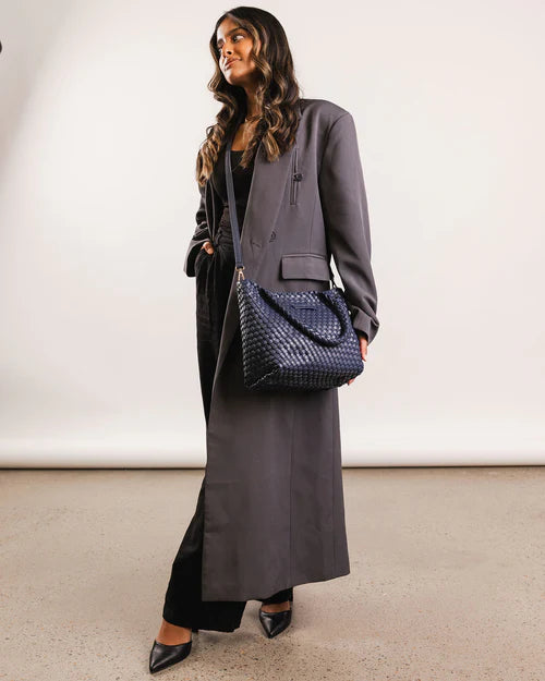 A stylish woven tote bag with top handles and an adjustable crossbody strap, perfect for effortless everyday elegance and versatility.