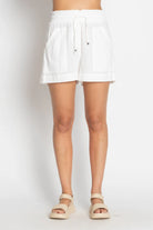 White cotton beach shorts with a relaxed fit and elastic waistband