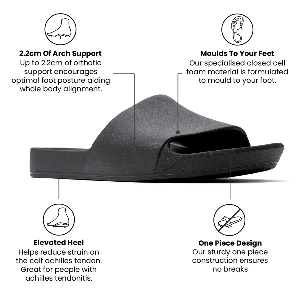 A pair of black arch support slides with a contoured footbed designed for comfort. The slides feature a sleek, minimalist design with a wide strap over the top and a cushioned sole for extra support.