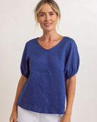 Lightweight denim-colored linen swing top with V-neck and relaxed fit, draping loosely over the body.