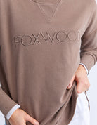 Foxwood Simplified Crew in chocolate brown with round neck, raw edge details, and side splits for a relaxed, everyday look.
