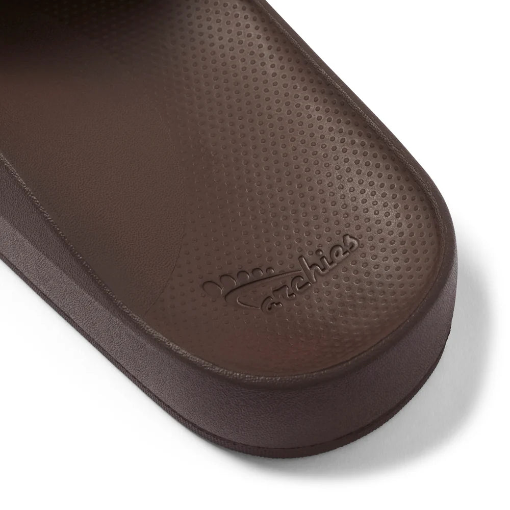 A pair of chocolate brown arch support slides with contoured footbeds and wide straps, designed for comfort and all-day wear.