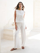 Coconut French linen coastal pants with a relaxed fit, elastic waistband, and frayed-edge hem, styled for an effortless summer look.