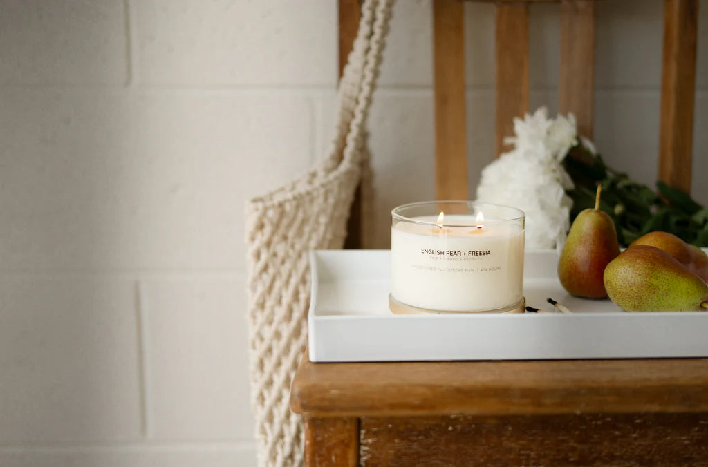 Meeraboo Gold Lid Soy Candle in a clear glass vessel with a brushed gold lid and double wicks, hand-poured with soy wax for long-lasting fragrance.
