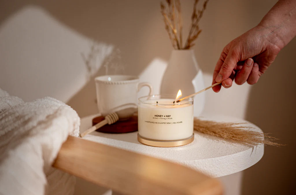 Meeraboo Gold Lid Soy Candle in a clear glass vessel with a brushed gold lid and double wicks, hand-poured with soy wax for long-lasting fragrance.
