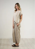 A natural white, box-fit top made from 100% stonewashed mesh linen, featuring short sleeves and a crew neckline. The airy, breathable fabric and relaxed silhouette offer a soft, comfortable feel with subtle gold strand detailing