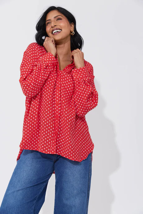 Vanuatu Shirt in Chilli with a relaxed fit, subtle square print, curved hem, and rolled tab sleeves showing a contrast colour block.