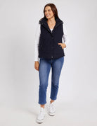Cord Puffer Vest in Dark Sapphire made from pinwhale cord, featuring a padded design and hood for added warmth.