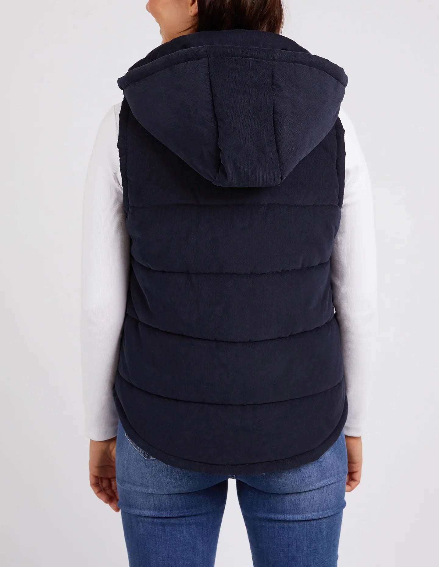 Cord Puffer Vest in Dark Sapphire made from pinwhale cord, featuring a padded design and hood for added warmth.