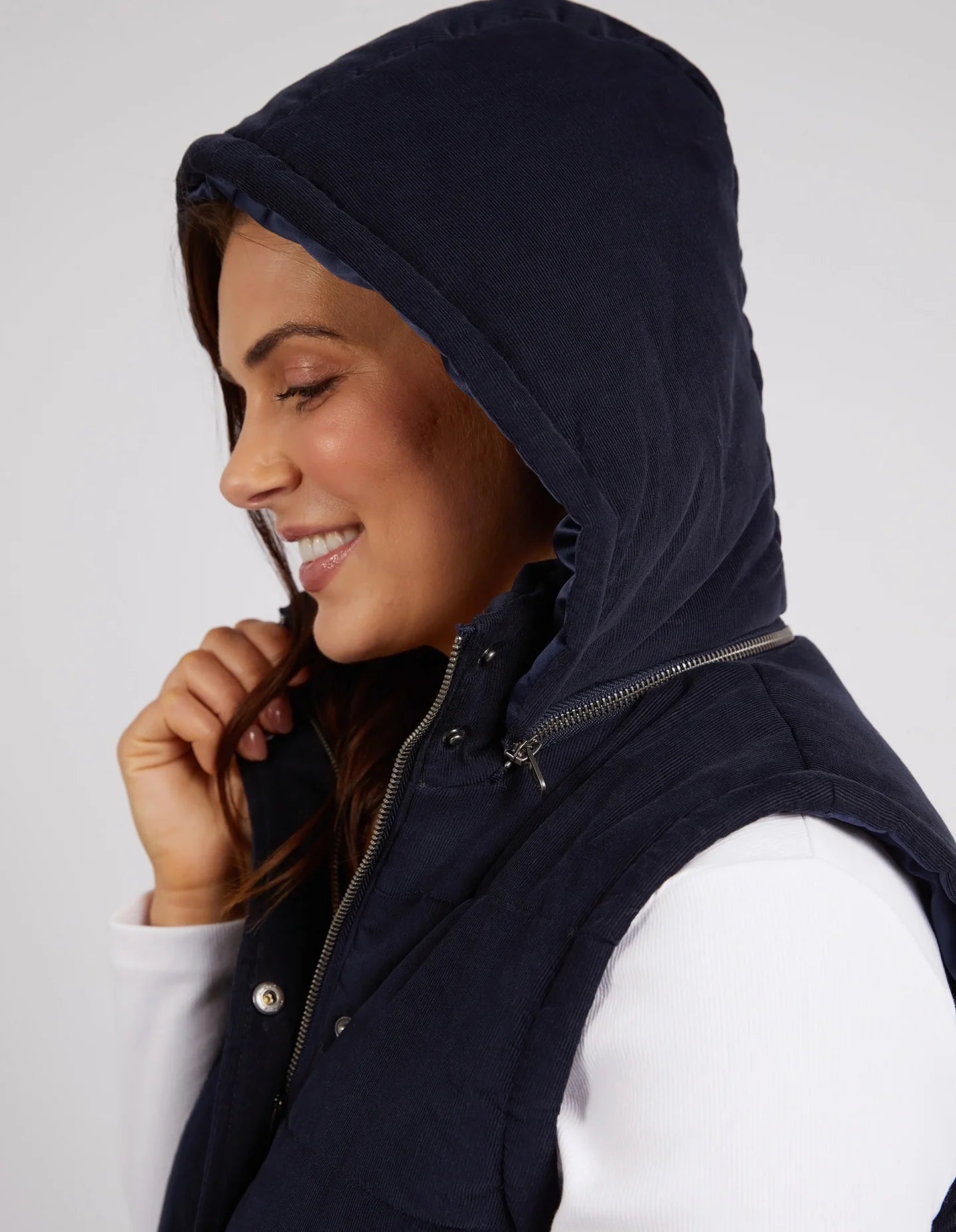 Cord Puffer Vest in Dark Sapphire made from pinwhale cord, featuring a padded design and hood for added warmth.