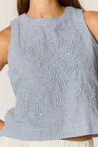 Cornelli Top featuring delicate embroidery and a sleeveless design, available in blue stripe, pink stripe and black.
