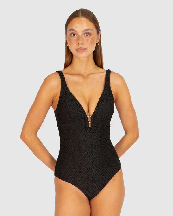 A stylish crochet-textured one-piece swimsuit with a dropped neckline, copper ring detail, and supportive under-bust panel for a chic, vintage-inspired look.