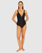 A stylish crochet-textured one-piece swimsuit with a dropped neckline, copper ring detail, and supportive under-bust panel for a chic, vintage-inspired look.