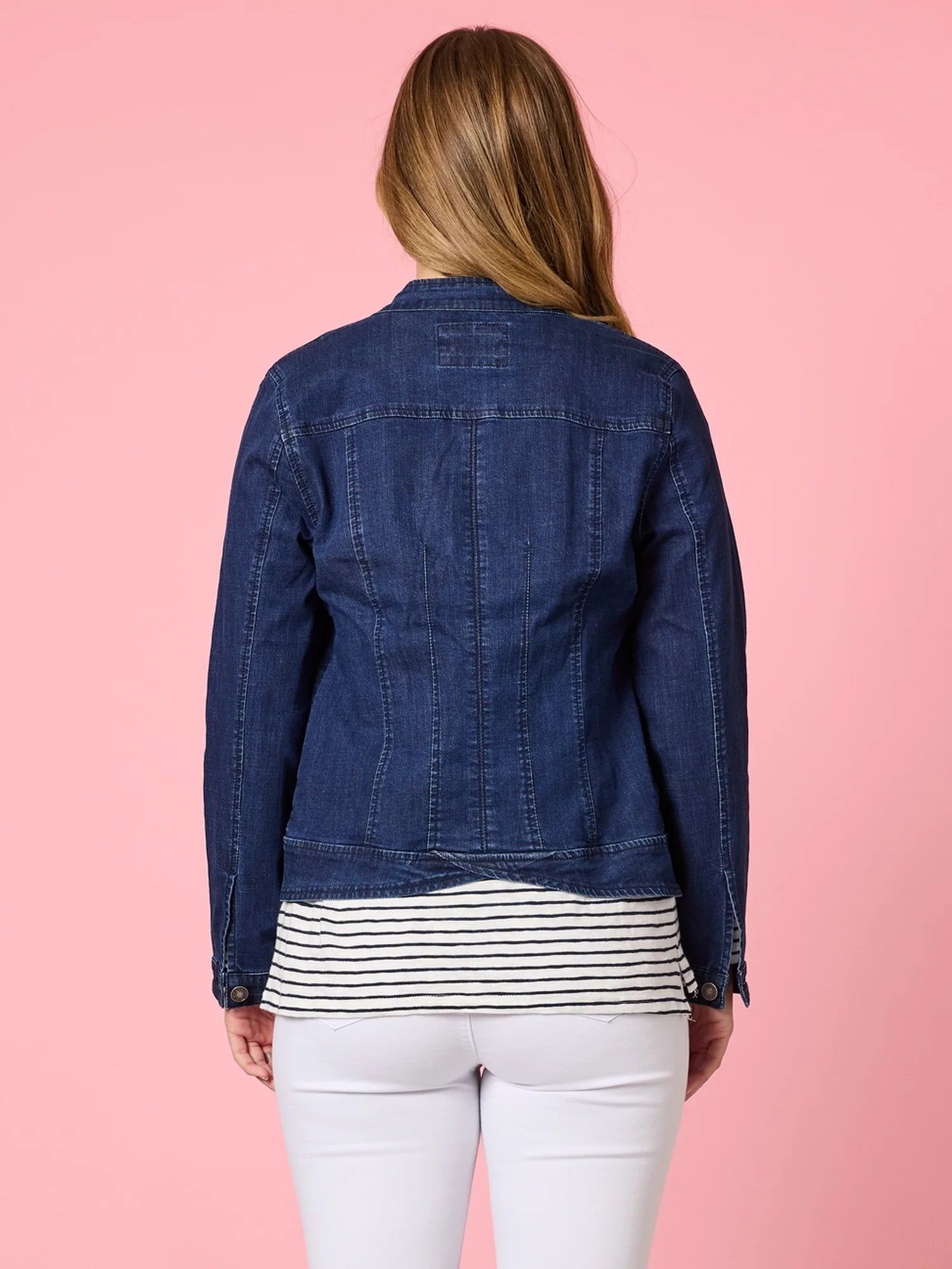 Woman wearing the Maggie Denim Jacket featuring a modern collarless design, button-up front, and structured fit in lightweight stretch denim.