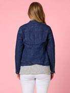 Woman wearing the Maggie Denim Jacket featuring a modern collarless design, button-up front, and structured fit in lightweight stretch denim.