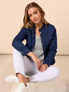 Woman wearing the Maggie Denim Jacket featuring a modern collarless design, button-up front, and structured fit in lightweight stretch denim.
