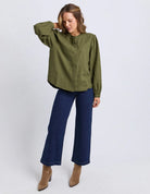 The Eleanor Shirt featuring a high neckline, button-through front, delicate chest embroidery, and softly gathered long sleeves in a relaxed, feminine silhouette.