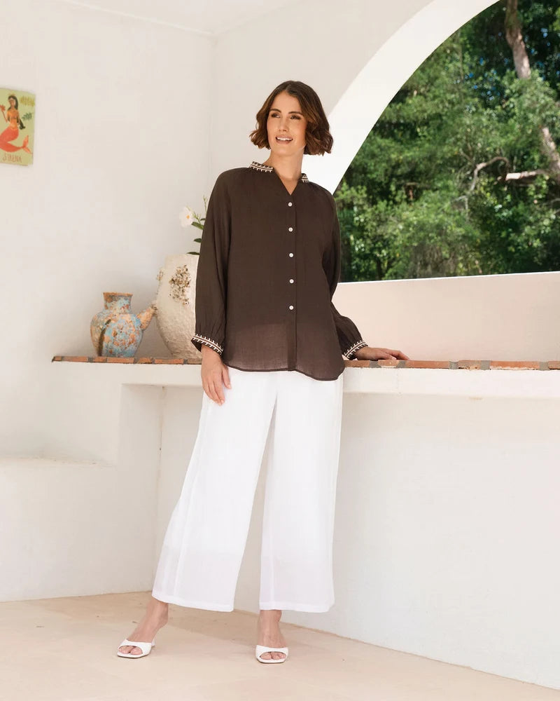 Ramie top featuring an embroidered collar and cuffs, notched neckline, gathered blouson sleeves and button-through front.