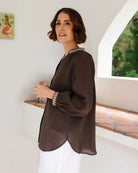 Ramie top featuring an embroidered collar and cuffs, notched neckline, gathered blouson sleeves and button-through front.