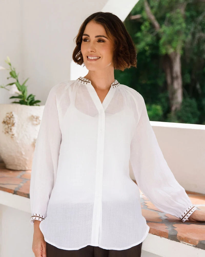 Ramie top featuring an embroidered collar and cuffs, notched neckline, gathered blouson sleeves and button-through front.