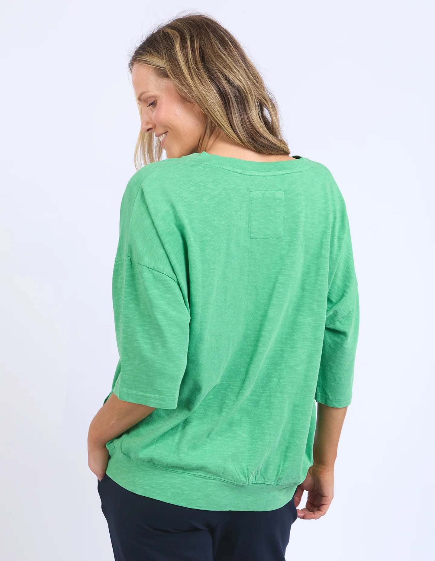 The Mazie Vee Neck in Greenbriar, a relaxed-fit cotton top with a spacious oversized design, features a flattering V-neckline, 3/4 length sleeves, and two front pockets, perfect for layering or casual wear