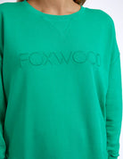 Foxwood Simplified Crew in bright green with round neck, raw edge details, and side splits for a relaxed, everyday look.