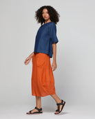Guru Skirt in Rust, featuring a 3/4 length, stretch drawstring waistband, front and back pockets, full lining and black contrast stitching.