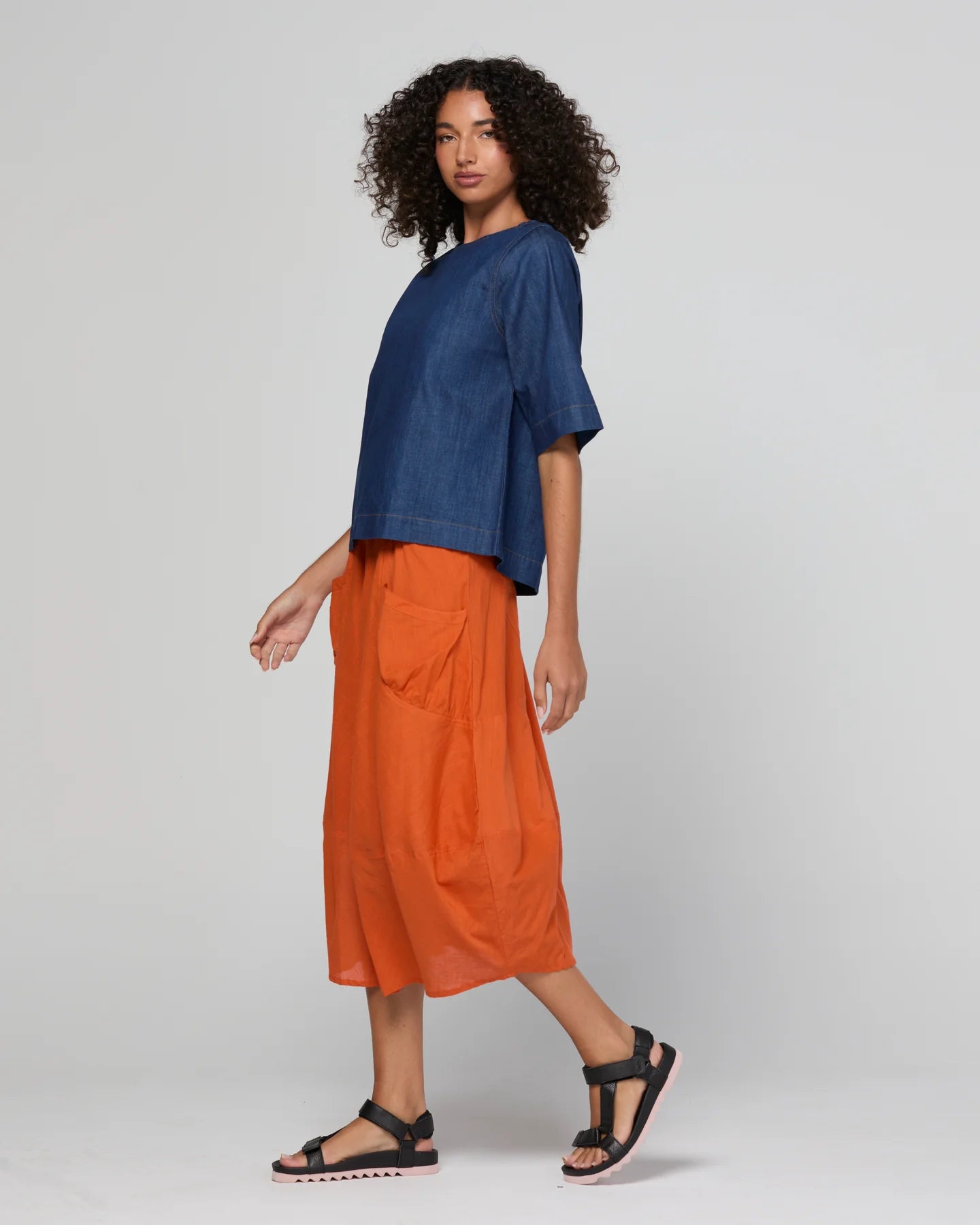 Guru Skirt in Rust, featuring a 3/4 length, stretch drawstring waistband, front and back pockets, full lining and black contrast stitching.