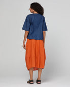Guru Skirt in Rust, featuring a 3/4 length, stretch drawstring waistband, front and back pockets, full lining and black contrast stitching.