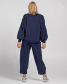 Boom Shankar Guru Track Pants in a relaxed fit with drawstring waistband, pleated front, contrast stitching, and back pocket SMILE logo