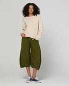 Woman wearing the Cord Guru Pant in Olive Green, featuring a relaxed 3/4 balloon-leg fit in soft cotton cord with a cool-toned khaki finish.