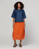 Guru Skirt in Rust, featuring a 3/4 length, stretch drawstring waistband, front and back pockets, full lining and black contrast stitching.