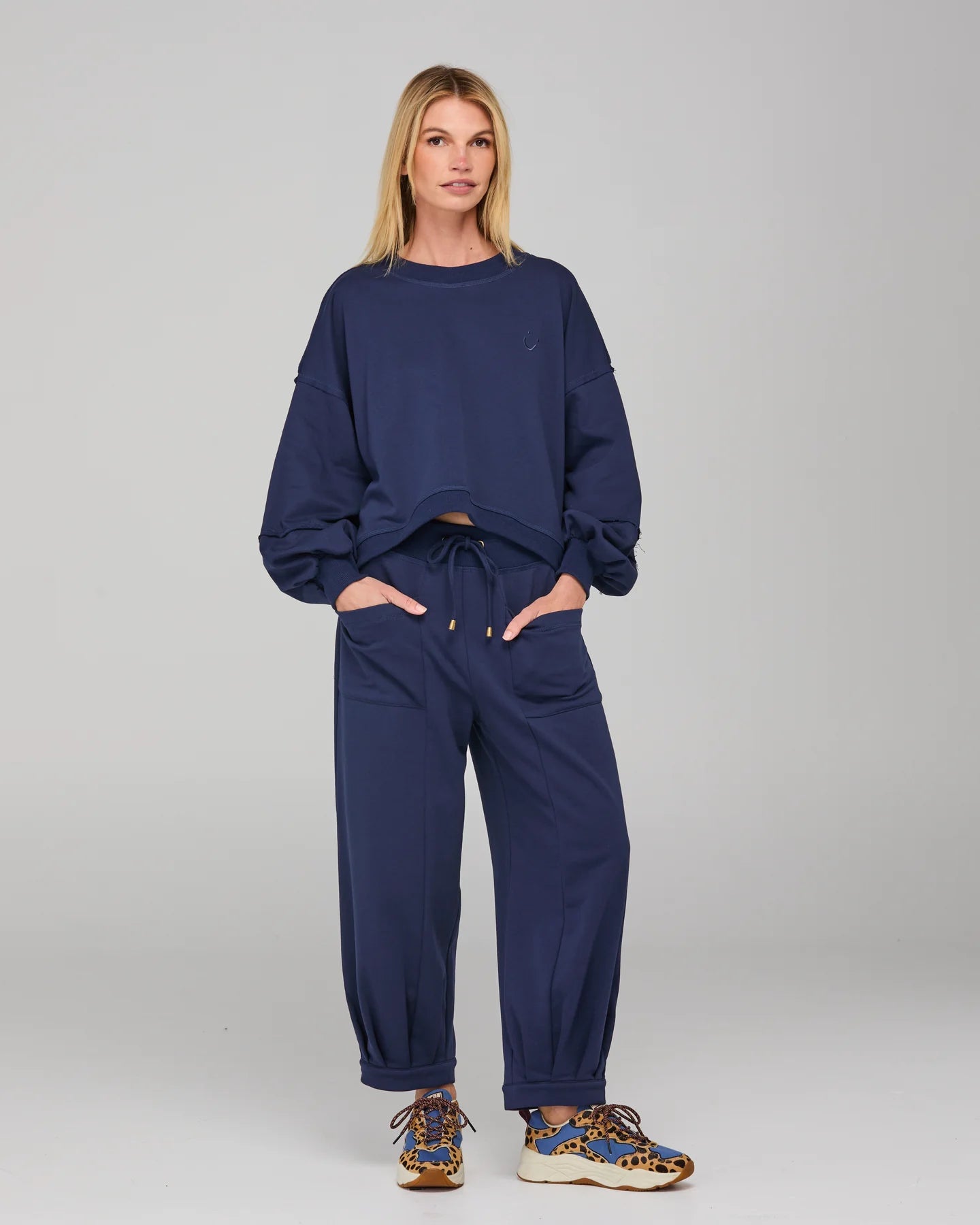 Boom Shankar Guru Track Pants in a relaxed fit with drawstring waistband, pleated front, contrast stitching, and back pocket SMILE logo