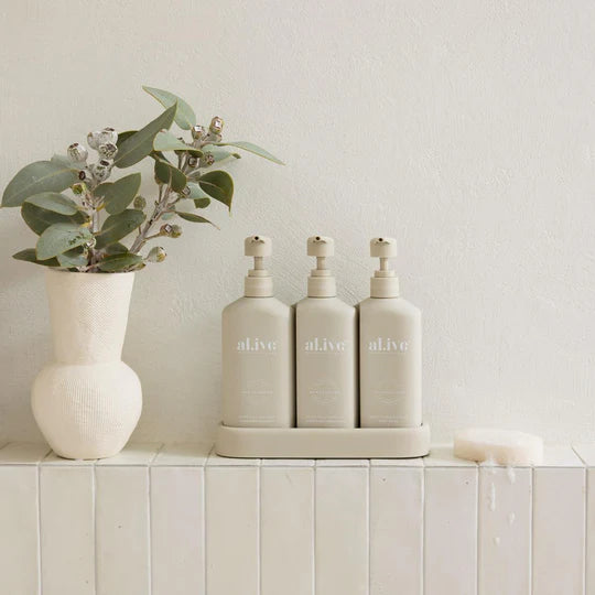 Hair & Body Trio – Hydrate featuring sulfate-free shampoo, nourishing conditioner, and rich body wash in a neutral stone-colored set.
