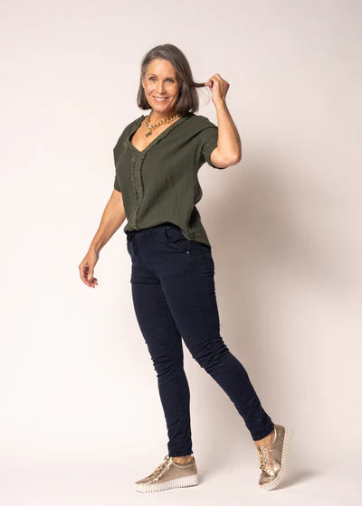 V-neck linen and cotton top with delicate lace detailing and subtle front fringing, relaxed fit, lightweight natural fabric.