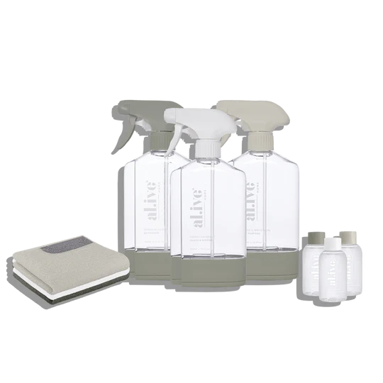 The Al.ive Home Cleaning Starter Kit, featuring three refillable 450ml bottles, each paired with 50ml cleaning concentrates for All Purpose, Bathroom, and Glass & Mirror cleaning. The kit includes three microfibre cloths, three bottle stations with connectors for customizable organization, and a sleek, modern design displayed on a clean countertop. The eco-friendly packaging is made with 30% post-consumer recycled plastic, showcasing a sustainable and effective cleaning solution.