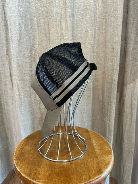 Rocks Hat in tan and black featuring a whale tail design on the front, snapback closure, and breathable mesh sides for a comfortable, adjustable fit.