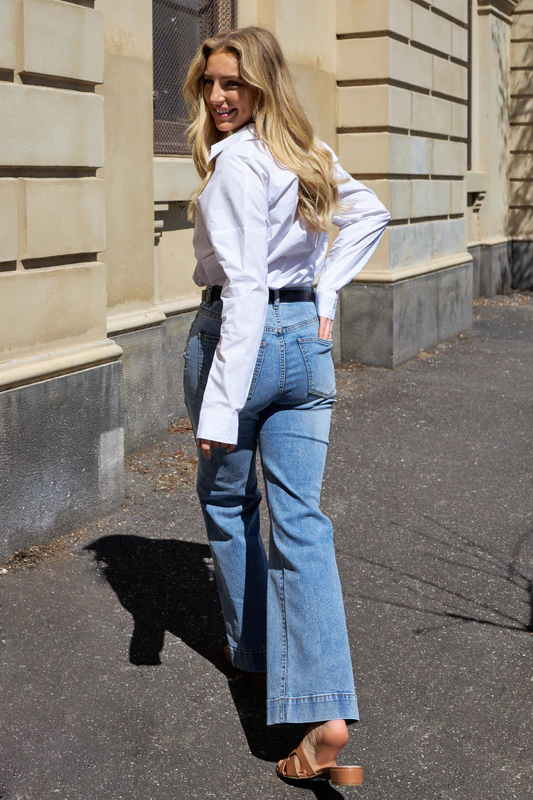 The Jayne Wide Leg Jean in vintage blue features a flattering high waist, super-stretch denim, front patch pockets, and a wide stitched hem.