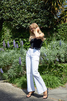 
The Jayne Wide Leg Jean in white features a flattering high waist, super-stretch denim, front patch pockets, and a wide stitched hem.
