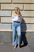 The Jayne Wide Leg Jean in vintage blue features a flattering high waist, super-stretch denim, front patch pockets, and a wide stitched hem.