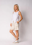 Justine Linen Top in breathable linen with draped false crossover front, V-shaped hemline, and delicate fringe detail along one side.