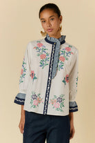Rubyaya Lara Frill Top in cream featuring floral embroidery, contrast trim and a ruffle neckline.