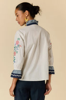 Rubyaya Lara Frill Top in cream featuring floral embroidery, contrast trim and a ruffle neckline.