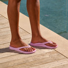 Lilac arch support thongs with contoured footbeds and ergonomic straps for enhanced comfort and stability.