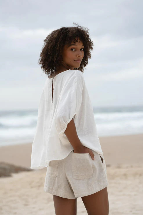 The Lily Pilly Tina Top in soft ivory linen features a relaxed silhouette, breathable lightweight fabric, and naturally textured weave.