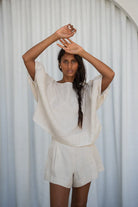 The Lily Pilly Tina Top in soft oatmeal linen is designed with a relaxed silhouette, lightweight feel, and natural textured weave.