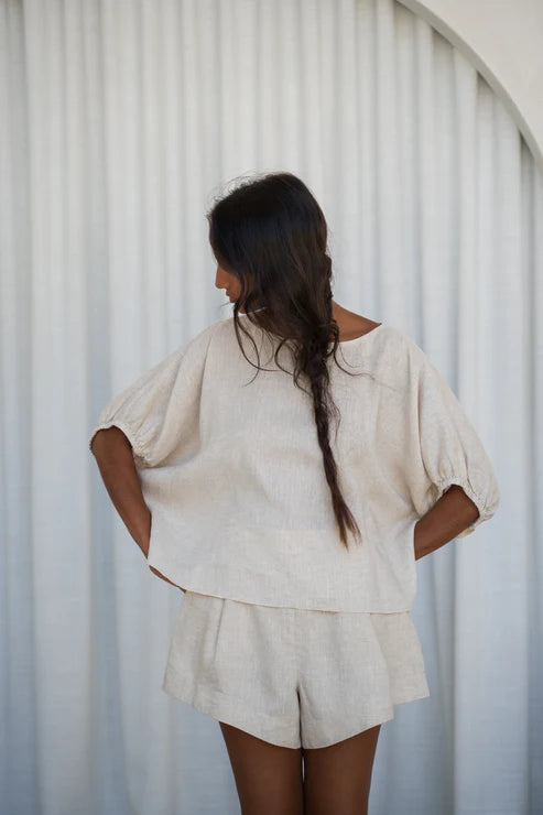 The Lily Pilly Tina Top in soft oatmeal linen is designed with a relaxed silhouette, lightweight feel, and natural textured weave.