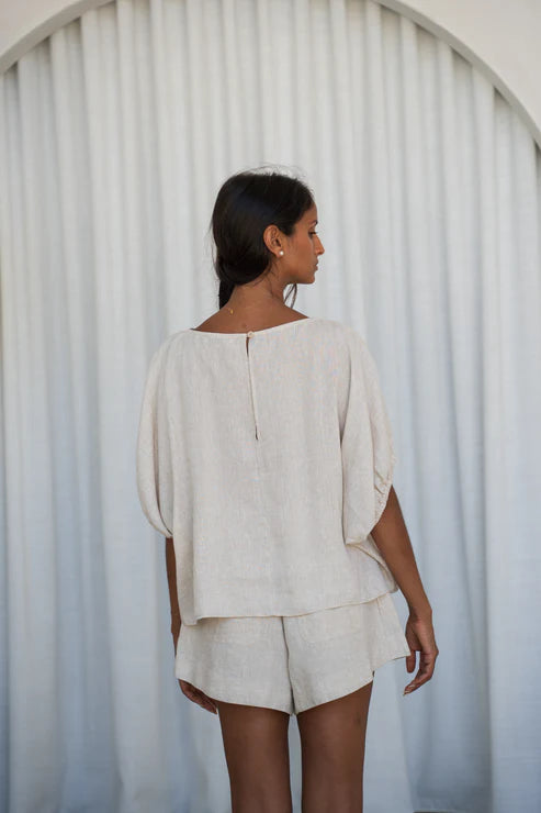 The Lily Pilly Tina Top in soft oatmeal linen is designed with a relaxed silhouette, lightweight feel, and natural textured weave.